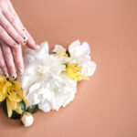 Closeup view of woman with beautiful hands on color background, space for text