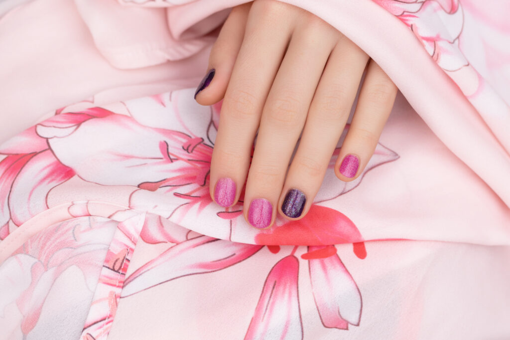 Pink nail design. Female hand with glitter manicure.