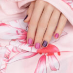 Pink nail design. Female hand with glitter manicure.