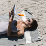 smiling-woman-reading-book-beach