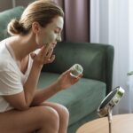 woman-applying-facial-mask-mirror
