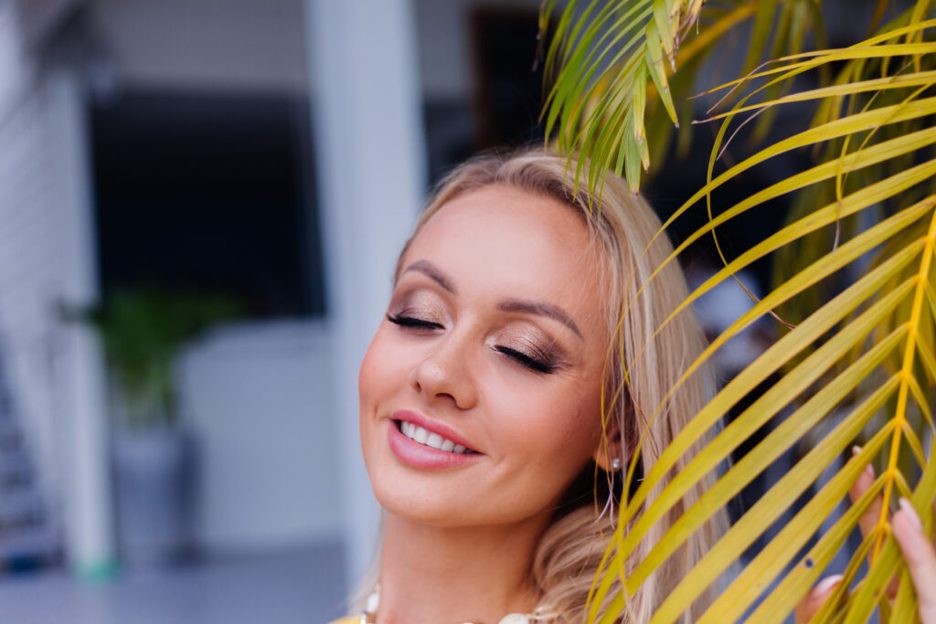 young-caucasian-calm-happy-pretty-woman-with-bright-evening-makeup-wearing-summer-yellow-dress-sea-shell-necklace