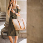 Young woman using phone by the old building