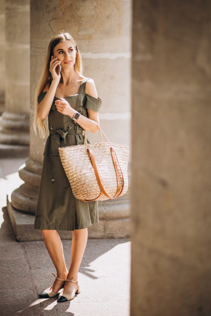 Young woman using phone by the old building